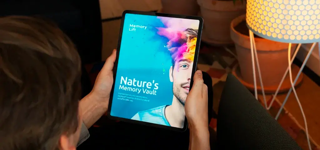 Person holding a tablet displaying "Nature's Memory Vault" ebook cover with a colorful powder explosion around a man's head