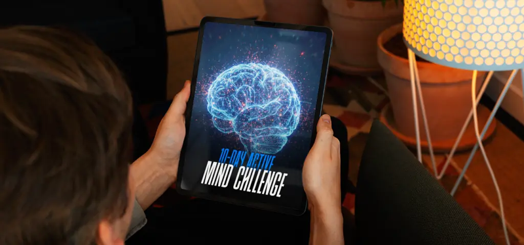 Person holding a tablet displaying "10-Day Active Mind Challenge" ebook cover with a glowing brain illustration